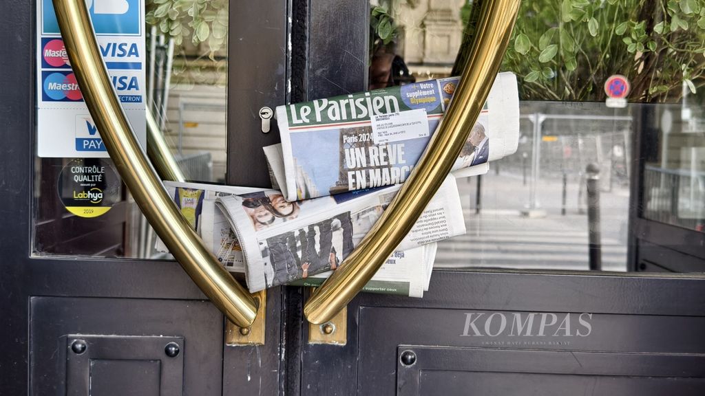 Tumpukan koran di depan salah satu restoran dekat Menara Eiffel, Rabu (24/7/2024). Restoran terpaksa tutup karena lokasinya berada di dekat Sungai Seine yang merupakan lokasi upacara pembukaan Olimpiade Paris 2024.